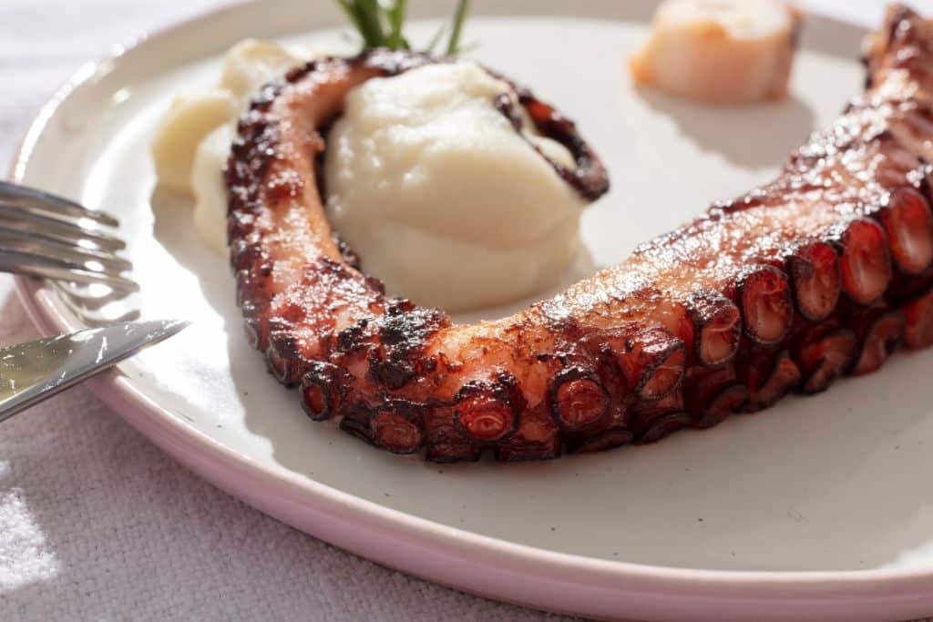 Pulpo a la parrilla con puré cremoso presentado en plato estilo recetas gourmet